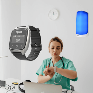 Nurse receiving page on wrist-worn pager while emergency light flashes in hallway